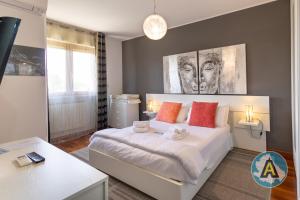 a bedroom with a large white bed with orange pillows at Moderno appartamento a Montesilvano 54a in Montesilvano