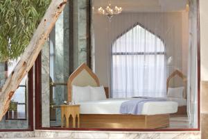 a bedroom with a bed with a large window at Es Saadi Marrakech Resort - Palace in Marrakech