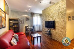 a living room with a red couch and a brick wall at Moderno appartamento a Montesilvano 54a in Montesilvano