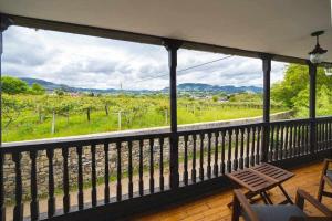 um quarto com uma varanda com vista para uma vinha em Casa PedroArias Rodiles em Villaviciosa