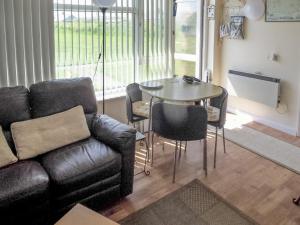 a living room with a couch and a table at Hollyhocks in Walcott