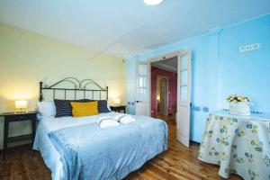 Un dormitorio azul con una cama con toallas. en Casa PedroArias Rodiles, en Villaviciosa