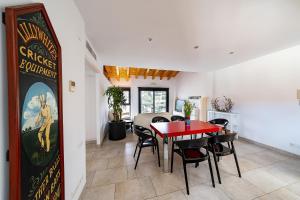 a dining room with a red table and black chairs at Apartaments Tee & Sea in Santa Cristina d'Aro