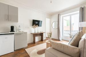 a living room with a couch and a kitchen at Apartment next Tour Montparnasse - Sable in Paris