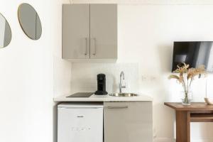 a kitchen with white cabinets and a sink at Apartment next Tour Montparnasse - Sable in Paris
