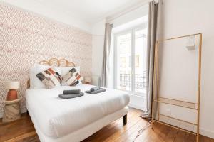a white bedroom with a white bed and a window at Apartment next Tour Montparnasse - Sable in Paris