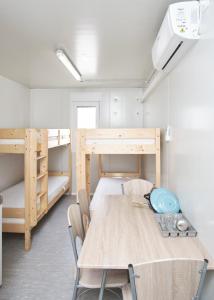 a room with a table and two bunk beds at Hostel Industrial in Čakovec