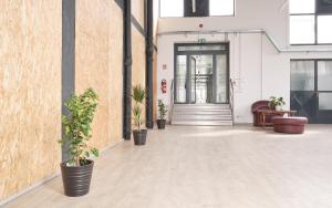 an empty room with potted plants in front of a door at Hostel Industrial in Čakovec