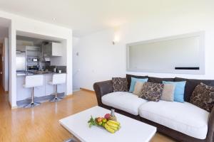 ein Wohnzimmer mit einem Sofa und einem Tisch mit Obst in der Unterkunft Home2Book Cozy Apt Santa Úrsula, Sea Views & Pool in Santa Úrsula