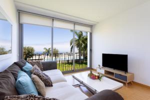 een woonkamer met een bank en een flatscreen-tv bij Home2Book Cozy Apt Santa Úrsula, Sea Views & Pool in Santa Úrsula