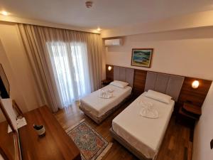 pokój hotelowy z 2 łóżkami i stołem w obiekcie Hotel Kaonia w Sarandzie