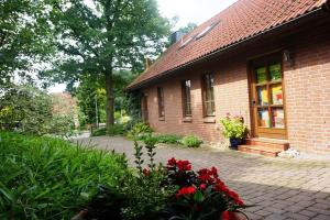 a brick house with red flowers in front of it at Haus Kunert 