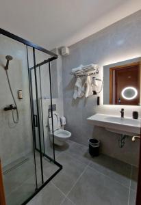 a bathroom with a shower and a sink and a toilet at Hotel Kaonia in Sarandë