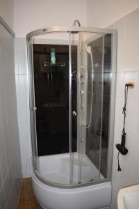 a shower with a glass door in a bathroom at Apartamenty Rynek X in Przemyśl