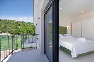 een slaapkamer met een bed en een balkon bij Villa Sokol with tennis court, heating pool, gym and sauna in Sokoli +46 foto's
