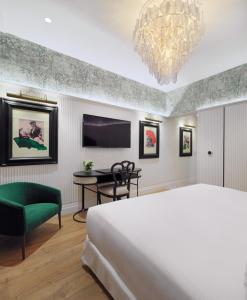1 dormitorio con cama, mesa y TV en H10 Corregidor Boutique Hotel, en Sevilla