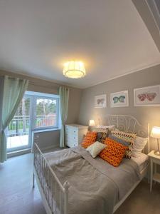 a bedroom with a large bed with orange pillows at Apartamenty Silence Blue Baltic in Pobierowo