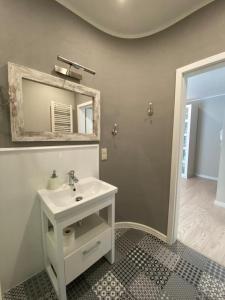 a bathroom with a white sink and a mirror at Apartamenty Silence Blue Baltic in Pobierowo