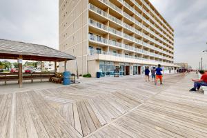 people walking on a boardwalk in front of a building at Rehoboth Beach --- Star of the Sea #604 in Rehoboth Beach