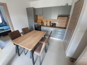 Il comprend une petite cuisine avec une table et des chaises en bois. dans l'établissement Apartmani Bozic-Tokic, à Krk