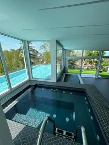 a jacuzzi tub in a house with windows at Villa Bauhaus Dream Deluxe in Siófok