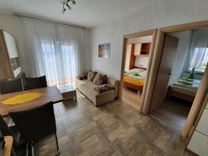 un salon avec un canapé et une table ainsi qu'une chambre dans l'établissement Apartmani Bozic-Tokic, à Krk
