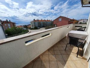 d'un balcon avec une table et une chaise. dans l'établissement Apartmani Bozic-Tokic, à Krk