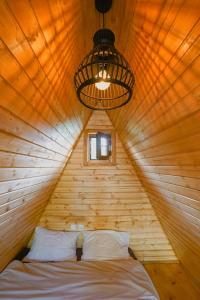 a bed in a wooden room with a ceiling at Mtskheta Cabin in Mtskheta