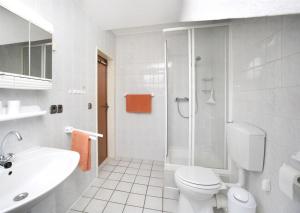 y baño blanco con aseo y ducha. en An der Seeve, Ferienhaus, en Jesteburg