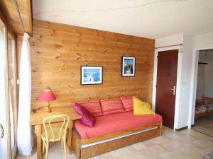 a couch in a room with a wooden wall at Appartement Auris, 3 pièces, 6 personnes - FR-1-297-27 in Auris