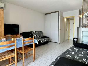 uma sala de estar com uma mesa e uma televisão em Appartement Argelès-sur-Mer, 1 pièce, 4 personnes - FR-1-225-422 em Argelès-sur-Mer
