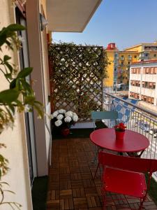 einen roten Tisch und Stühle auf einem Balkon mit Hecke in der Unterkunft Frebi's Home - Bed & Breakfast in Neapel