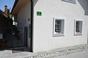 a white building with two windows with potted plants at Krakovska apartments in Ljubljana