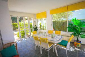 a dining room with a table and chairs on a porch at Villa Monet ONLY FAMILIES in Cambrils