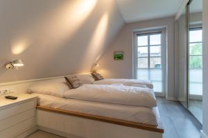 um quarto com 2 camas e uma janela em Reetdachhaus Kleine Krabbe Reetdachhaus Kleine Krabbe em Ording
