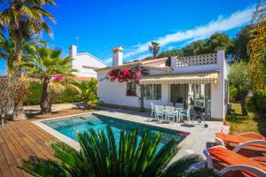 a villa with a swimming pool in front of a house at Villa Monet ONLY FAMILIES in Cambrils
