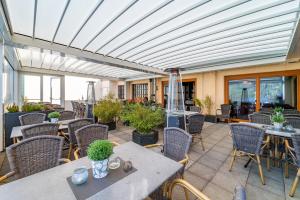 a patio with tables and chairs and windows at Bierenbacher Hof in Nümbrecht