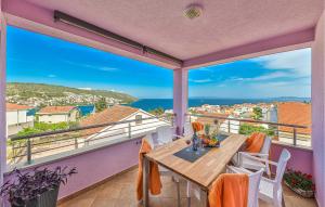 balcón con mesa y vistas al océano en Amazing Apartment In Okrug Gornji With Kitchen, en Trogir