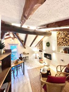 un soggiorno con soffitti in legno, tavolo e sedie. di Maison de la montagne - Chambres & Jacuzzi ad Arvier
