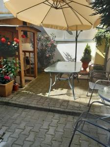 een tafel en stoelen met een parasol op een patio bij U paní malířky in Valtice