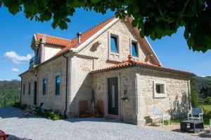 a large stone house with a red roof at Quinta do Bairro in Vieira do Minho
