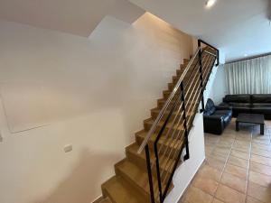 a staircase in a living room with a couch at Adosados Palm Beach Altamar in Alcossebre