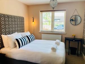 a bedroom with a large white bed with towels on it at The Red Lion Stevington in Stevington