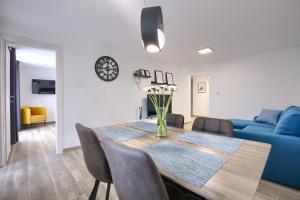 uma sala de jantar com uma mesa e um sofá azul em Apartment Marin 2 near the beach em Banjole