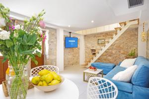 een woonkamer met een bank en een tafel met een fruitschaal bij Villa Sokol with tennis court, heating pool, gym and sauna in Sokoli