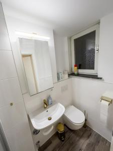 biała łazienka z toaletą i umywalką w obiekcie Messe-Apartment für 5 Gäste mit Balkon und Lift w Hanowerze