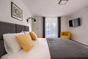 a bedroom with a bed with yellow and white pillows at Apartment Marin 2 near the beach in Banjole