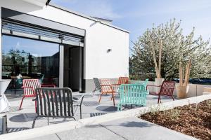 - un ensemble de chaises et de tables sur une terrasse dans l'établissement Boardinghouse Plattling, à Plattling