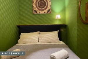 um quarto com uma cama com uma parede verde em Pisos Baza, Tres apartmentos en Baza Central em Baza