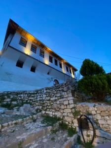 un edificio con luces en la parte superior de una pared de piedra en Guest House LION, en Berat